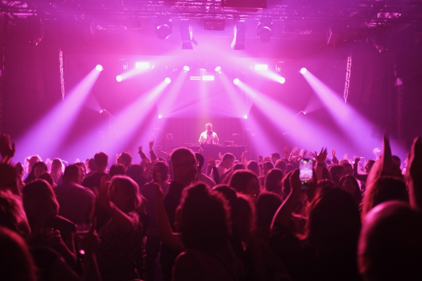 Dancefloor under pink lights at a DJ Denden event